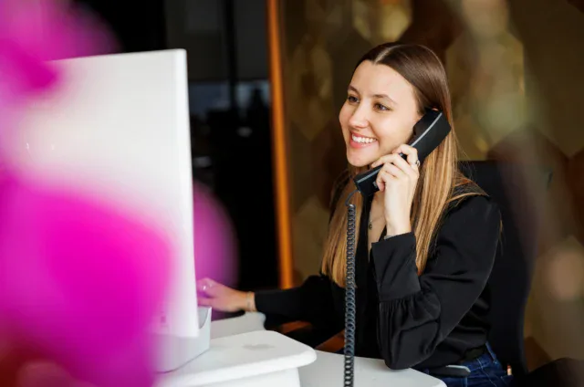 Una mujer atiende una llamada telefónica en una oficina.
